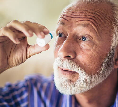 Elderly man using Eye Drops for Glaucoma